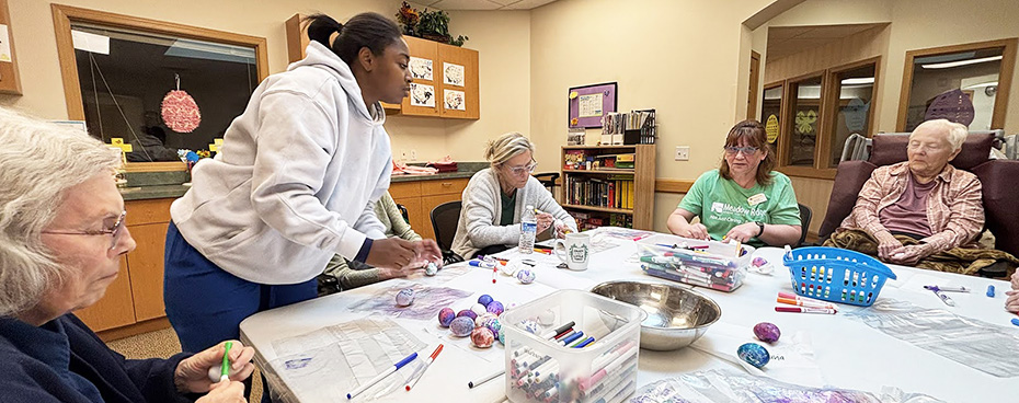 Meadow View seniors and staff color Easter eggs together
